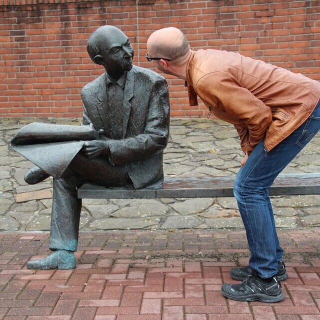 A man and statue of a man staring at eachother.